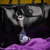 Porte-clés Gomee Keymate esprit pie Sussie de KPop Demon Hunters, fixé à un sac à main en cuir noir.