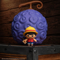 Officially licensed Netflix One Piece Monkey D Luffy Gomee Keymate keyring standing in front of a Devil Fruit Squishy by Cinereplicas.