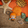 Officially licensed One Piece Nami Gomee Keymate keyring resting on beach sand with sea shells.